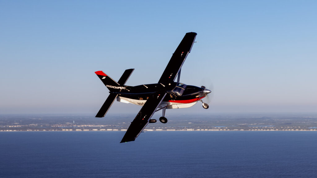 The DAHER Kodiak100 in flight over the water