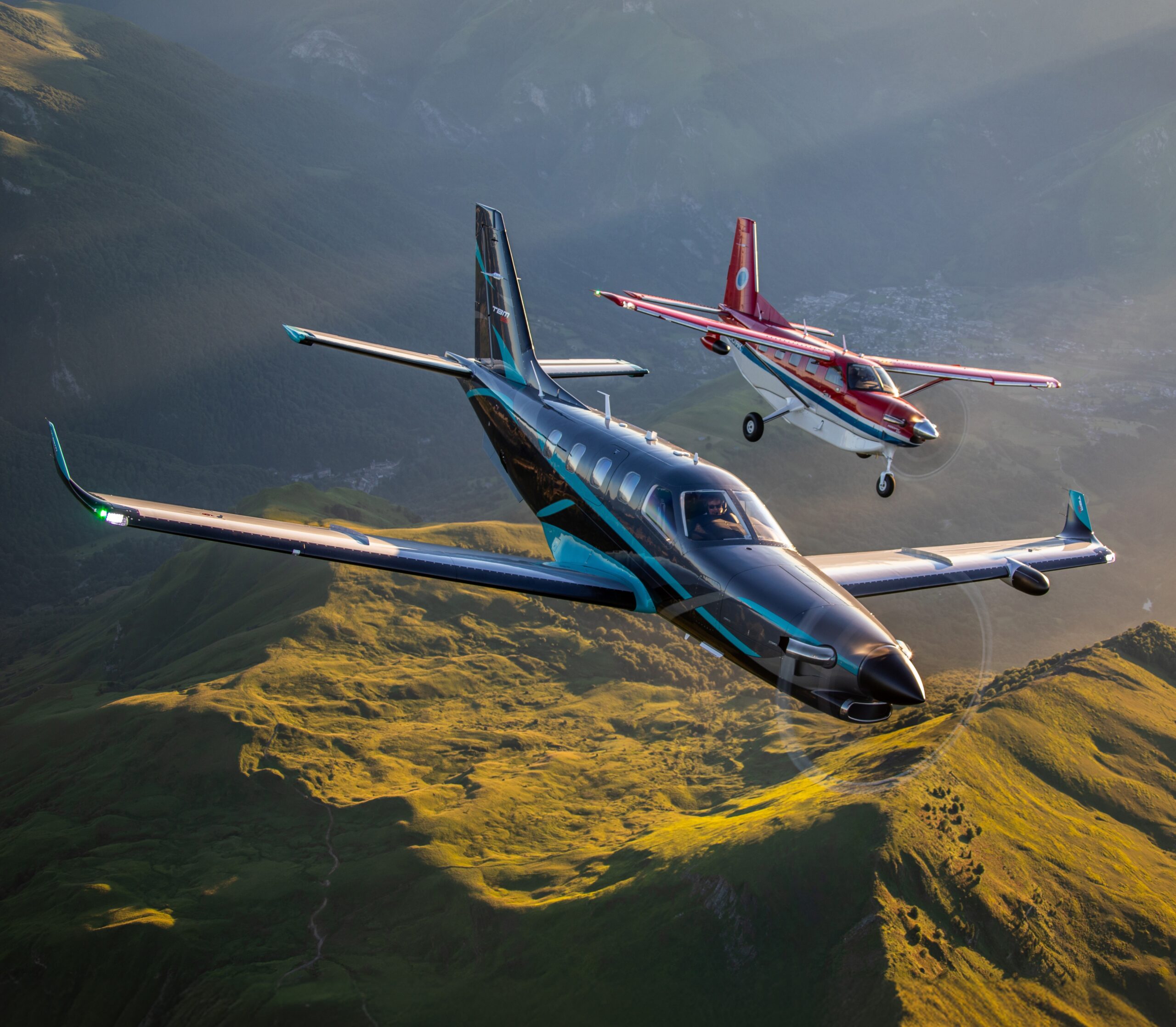 The TBM960 and the Kodiak100 flying in formation over mountains