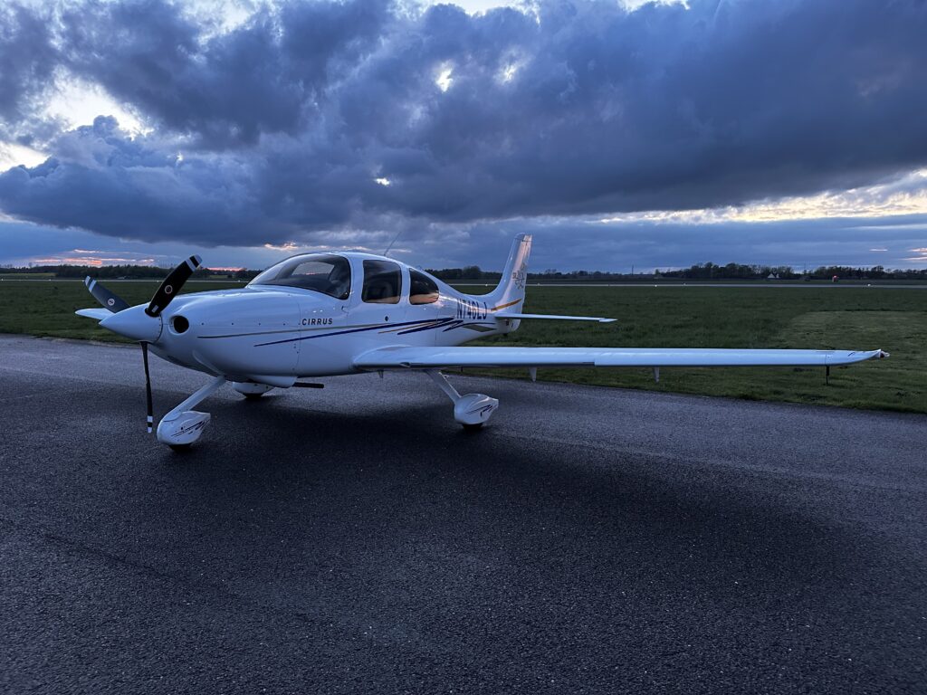 A Cirrus SR20 parked on the apron in a small airport. 