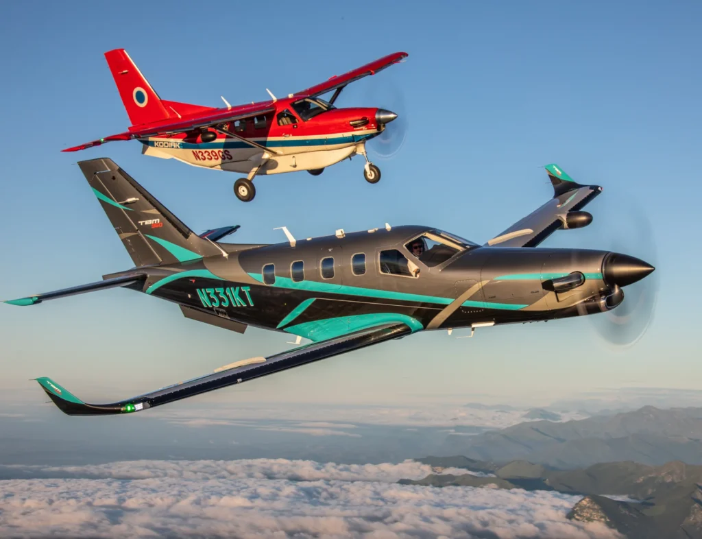 A TBM 960 and a Kodiak 100 flying in formation in clear skies