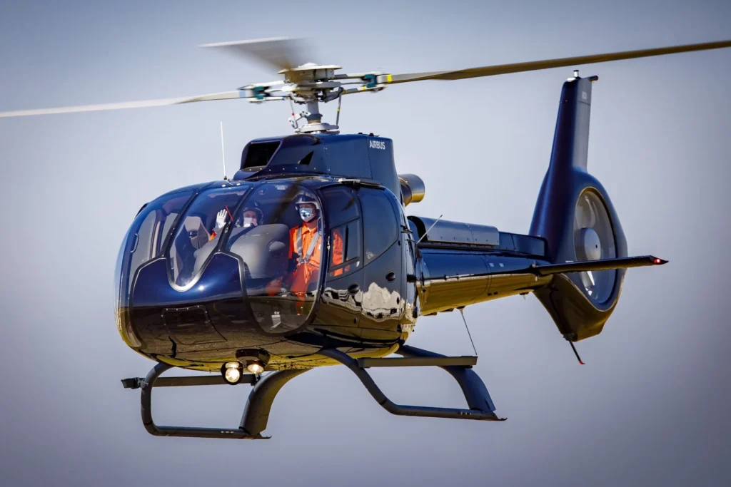 Airbus H130 in flight with two persons on board. Photo by Eric Raz
