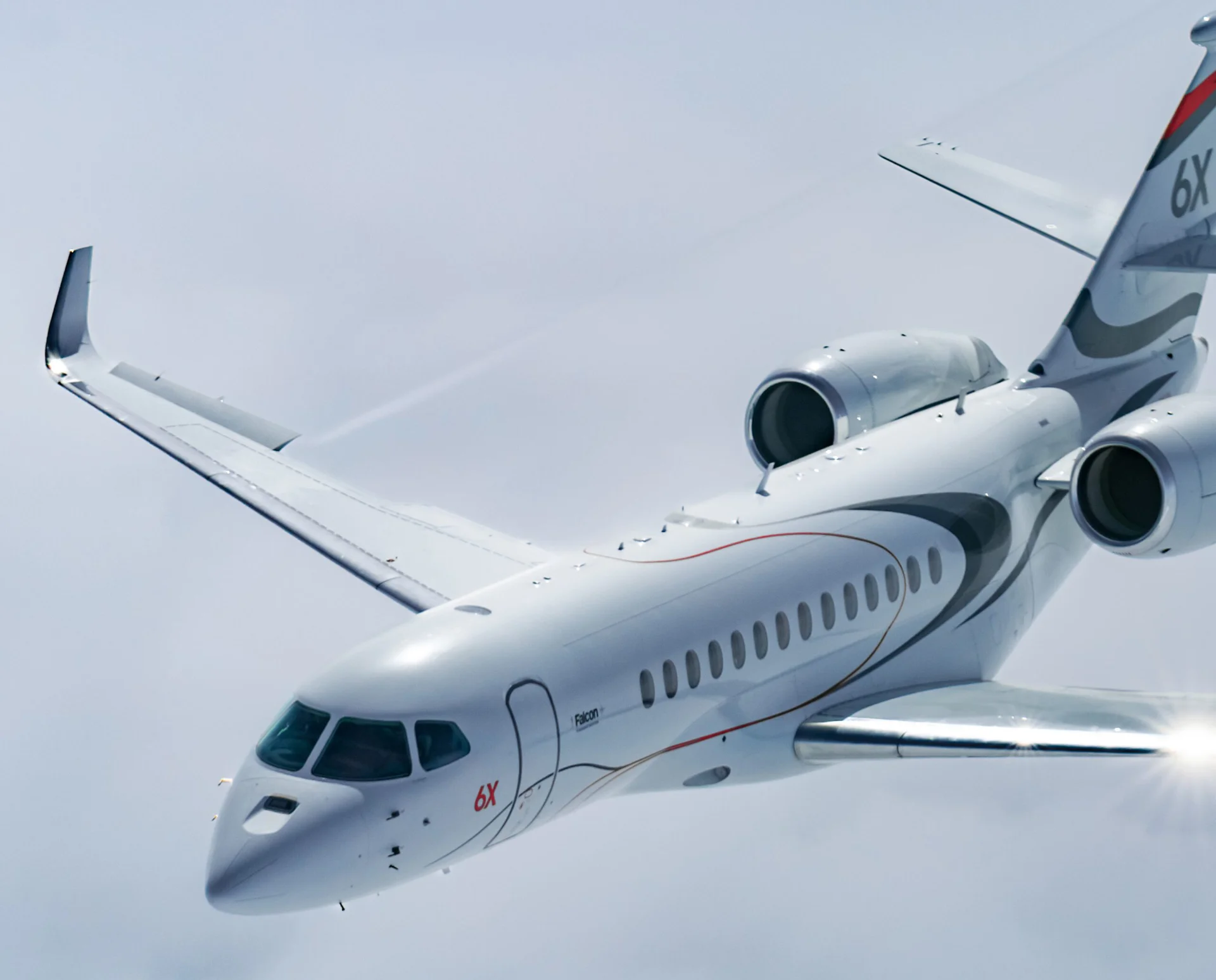 Dassault Falcon 6X in cruise flight over the cloud layers.