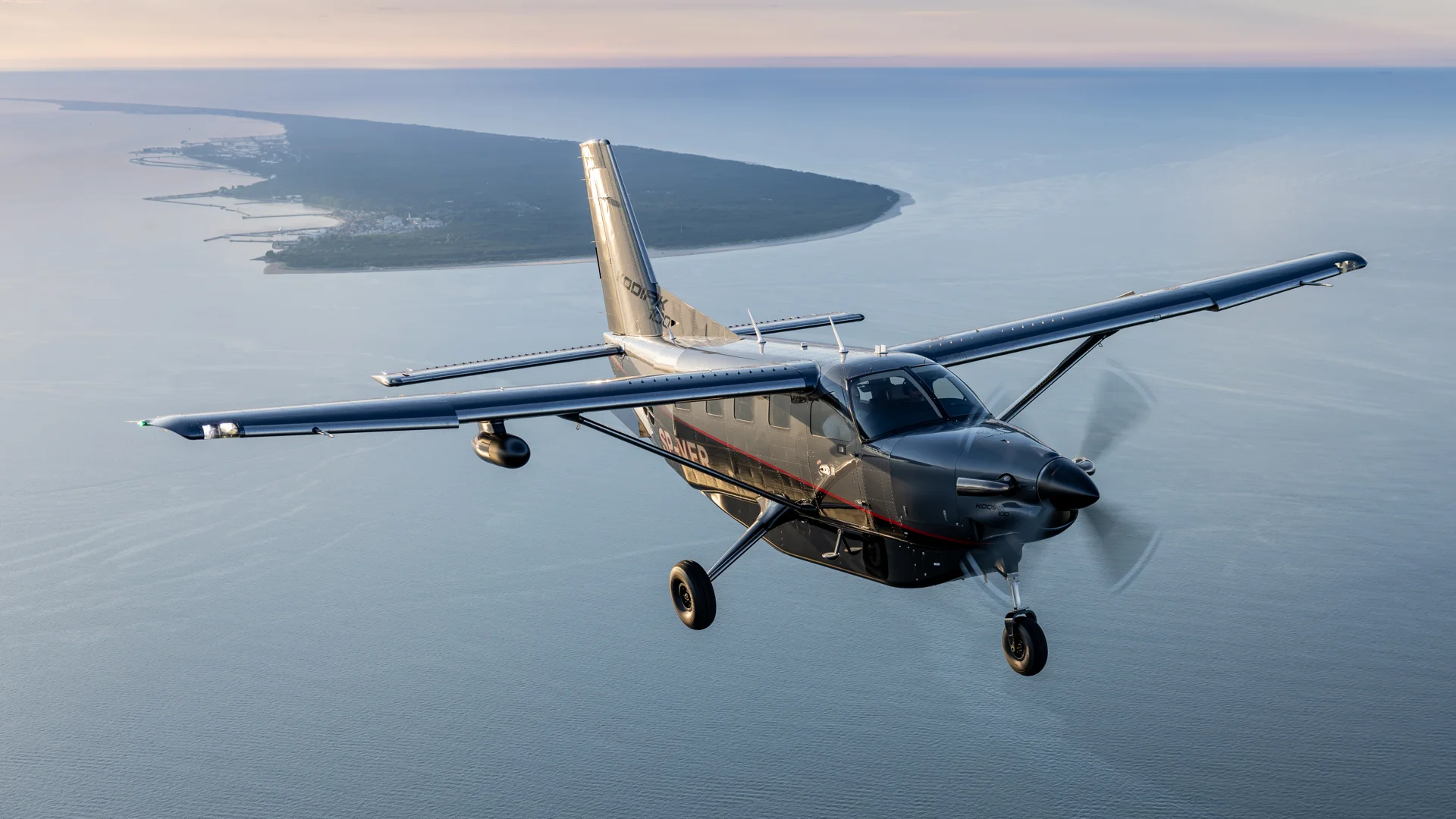 Kodiak 100 flying over the sea in clear weather