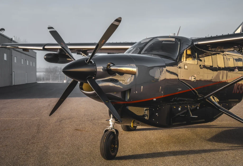 The Daher Kodiak 100 parked close to a hangar. 