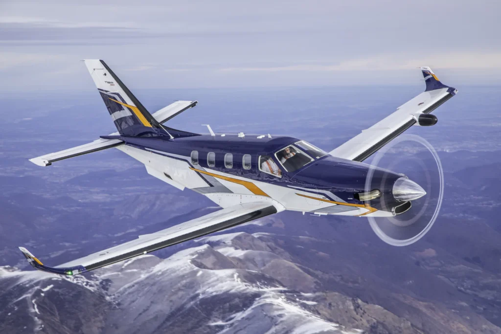 The Daher TBM 980 in flight over mountain ridge in clear weather
