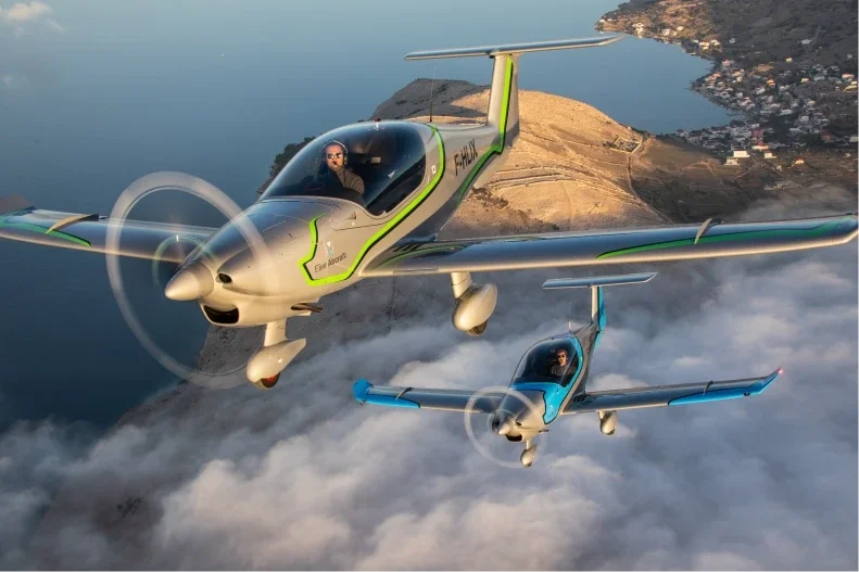 Two Elixir Aircraft in flight over coast line of southern France, photographed in the sun set.